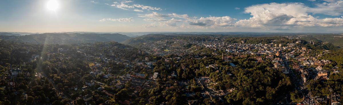 "Vista panorâmica das encantadoras ruas de Gramado com bela arquitetura europeia e natureza exuberante, refletindo o privilégio de morar nesta cidade encantadora."